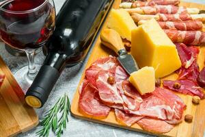 Antipasto background. Various meat and cheese snacks with red wine. photo