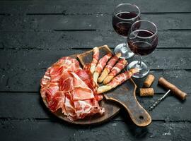 Spanish ham with red wine and breadsticks. photo