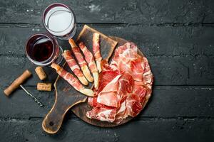 Spanish ham with red wine and breadsticks. photo