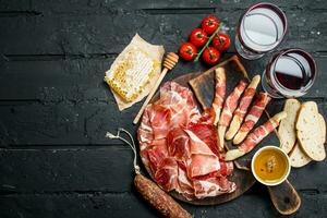 Spanish ham with red wine and breadsticks. photo