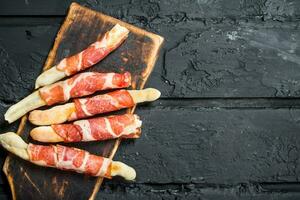 Antipasto background.Breadsticks with bacon. photo