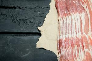 Raw bacon on paper. photo