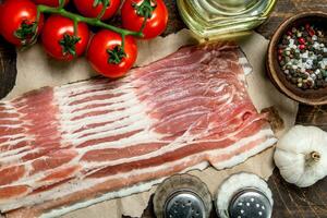 Raw bacon with tomatoes and spices. photo
