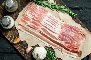 Raw bacon with rosemary and spices. photo