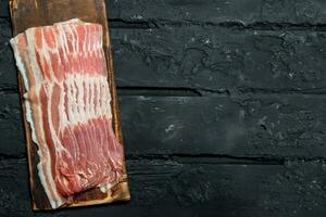 Raw bacon on a cutting Board. photo