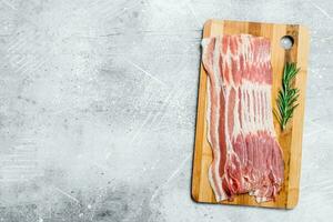 Raw bacon on the Board. photo