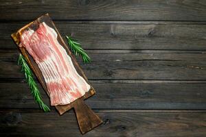 Raw bacon with rosemary. photo