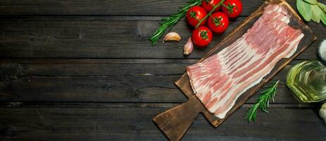 Raw bacon with tomatoes and herbs. photo