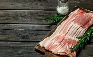 Raw bacon with rosemary and spices. photo