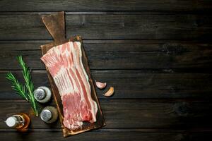 Raw bacon with rosemary and spices. photo