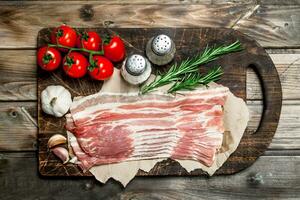 Raw bacon with vegetables, herbs and spices. photo