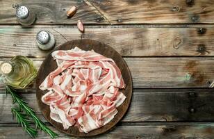 Raw bacon with rosemary and olive oil. photo