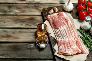 Raw bacon with vegetables, herbs and spices. photo