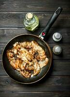 Fried bacon in a pan with spices. photo