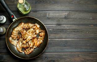 Fried bacon in a pan with spices. photo