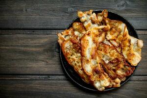 Fried bacon in a pan with spices. photo