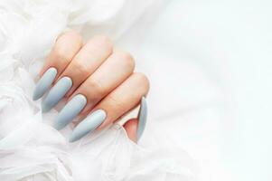 Grey nails on white lace background. photo