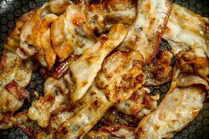 Fried bacon in a frying pan. photo