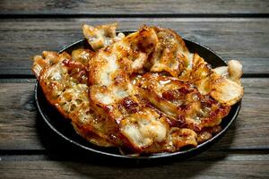 Fried bacon in a pan with spices. photo