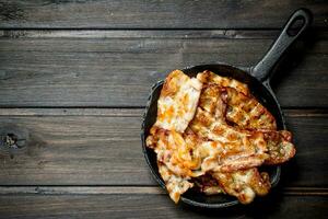 Fried bacon in a frying pan. photo