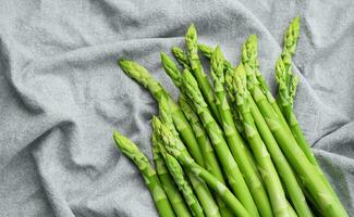 Fresh green asparagus on  textile background. photo