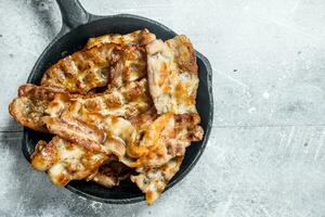 Fried bacon in a frying pan. photo