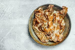 Fried bacon in a frying pan. photo