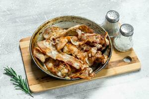 Fried bacon in a pan with spices. photo