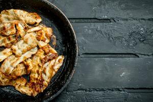 Fried bacon in a frying pan. photo