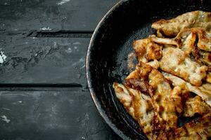 Fried bacon in a frying pan. photo