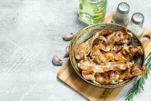 Fried bacon in a pan with spices. photo