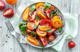 Green salad from leaves and tomatoes photo