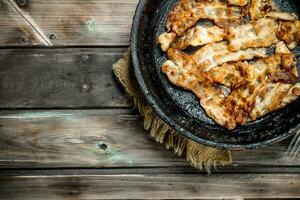 Fried bacon in a pan. photo