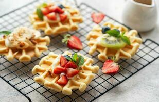 Freshly baked waffles with strawberries and blueberries photo