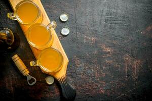 Glasses of beer on a wooden cutting Board. photo