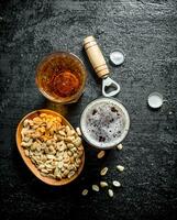 Beer in glasses with peanuts in bowl. photo