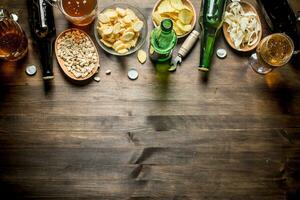 Beer and an assortment of different types of snacks. photo