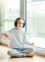 Cute little girl listening to music in headphones photo