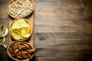 Peanuts, chips and crumbs in the bowls. photo