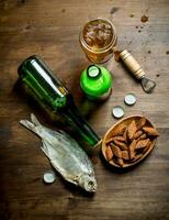 Beer with crumbs in bowl and dried fish. photo