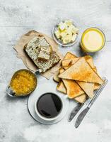 Breakfast. Toasted bread with butter, honey and orange jam. photo