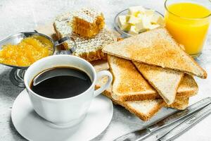 Breakfast. Toasted bread with butter, honey and orange jam. photo