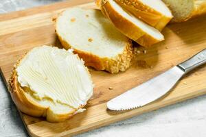 Breakfast. Fresh bread and butter on a wooden Board. photo