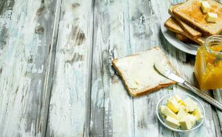 Breakfast. Toasted bread with butter and orange jam . photo