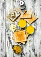 Breakfast. Toasted bread with butter, honey and orange juice . photo