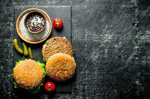 Burgers with spices, tomatoes and cucumbers. photo