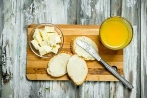 Fresh bread with butter and orange juice . photo