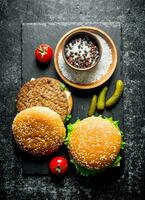 Burgers with spices, tomatoes and cucumbers. photo