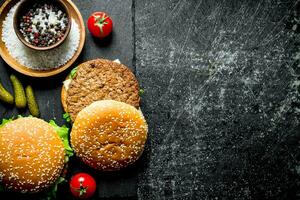 Burgers with spices, tomatoes and cucumbers. photo