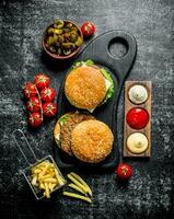 Burgers with fries,tomatoes and jalapenos in bowl . photo